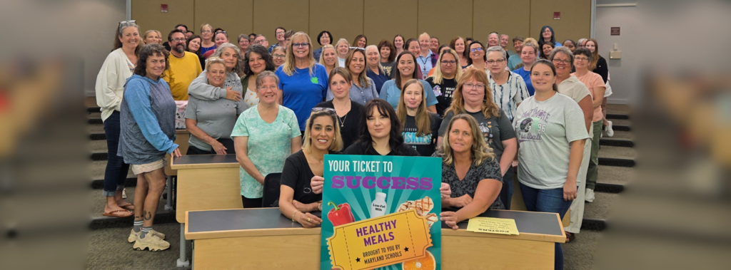 Group of Lunch ladies and gentlemen together holding a maryland eats sign