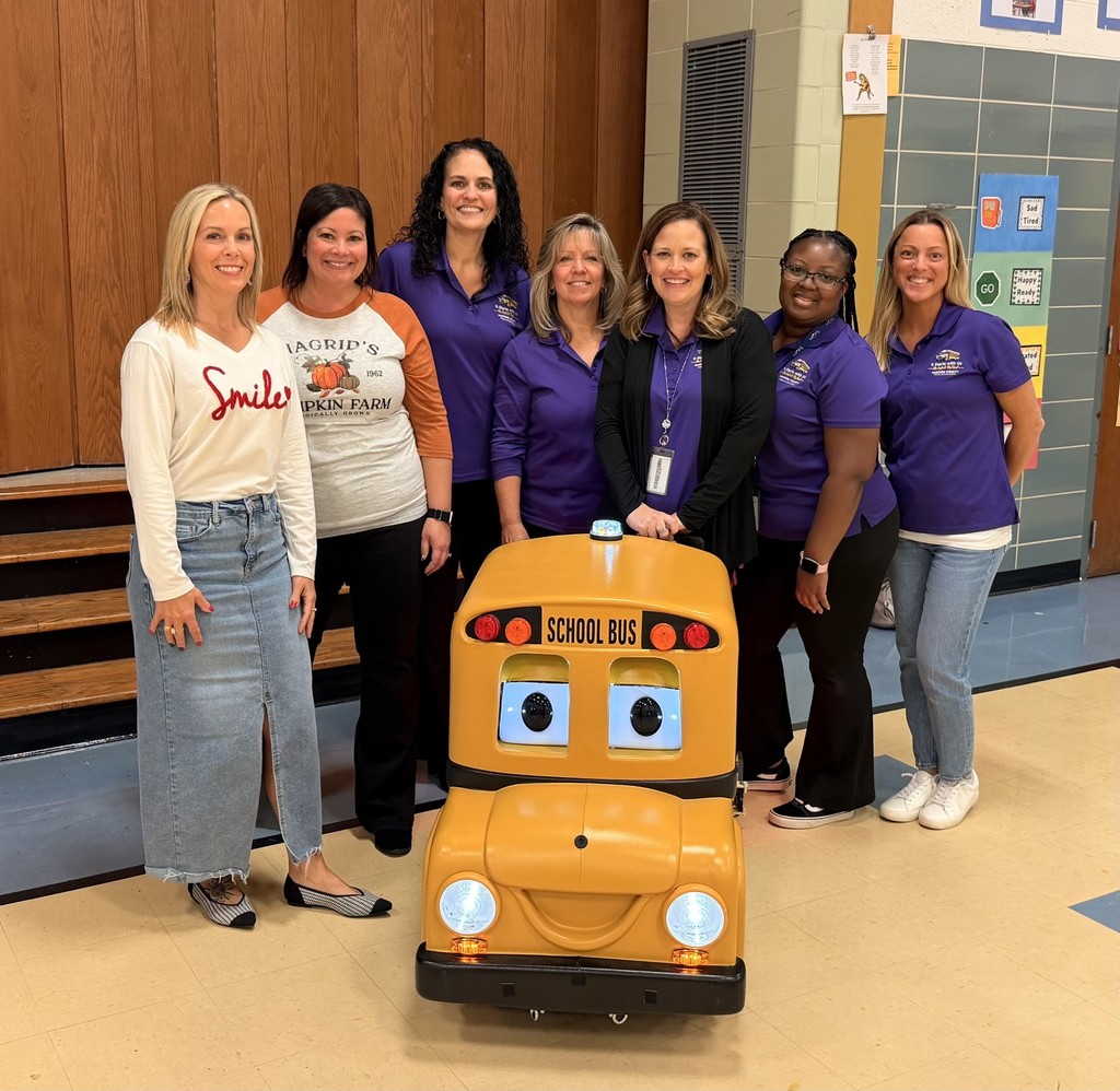 Office of Transportation members stand with Ms. Drumgoole and Mrs. Corun and Buster the Bus