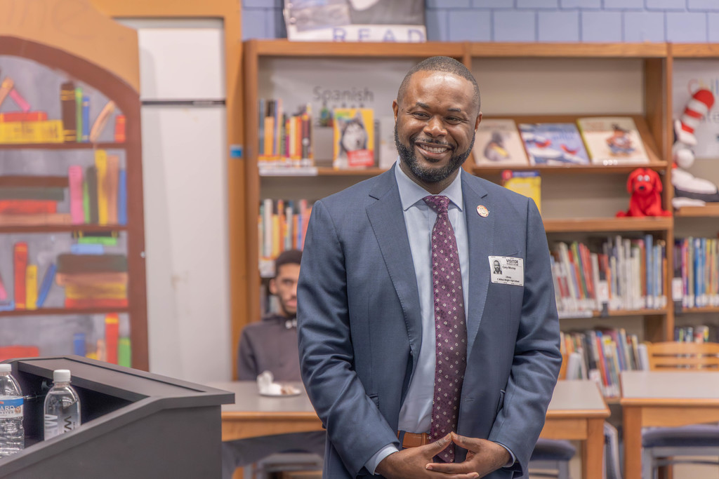 Senator McCray standing in a suit in front of a room.