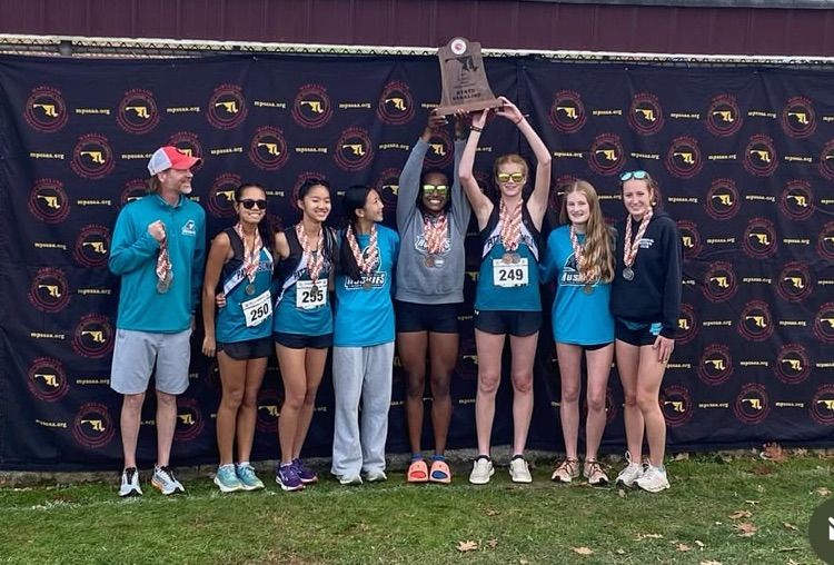 Girl runners folding trophy with coach