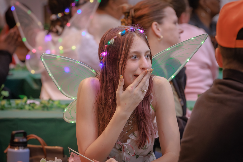 Young woman looking surprised wearing fairy wings