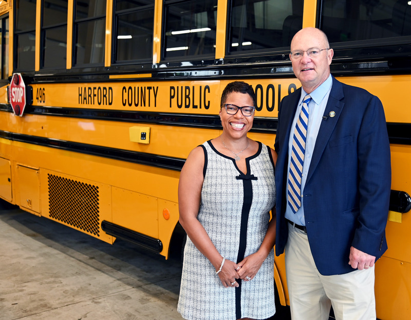 Dr. mack and Mr. Cassilly pose in front of a school bus