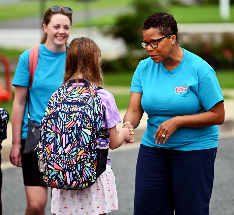 Dyann Mack shakes a student's hand.