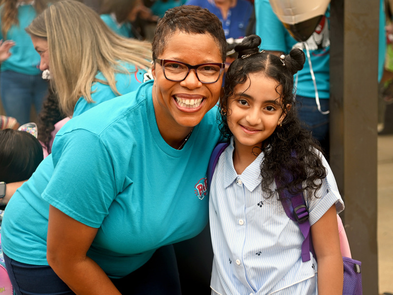 Dyann Mack and a student pose and smile for the camera