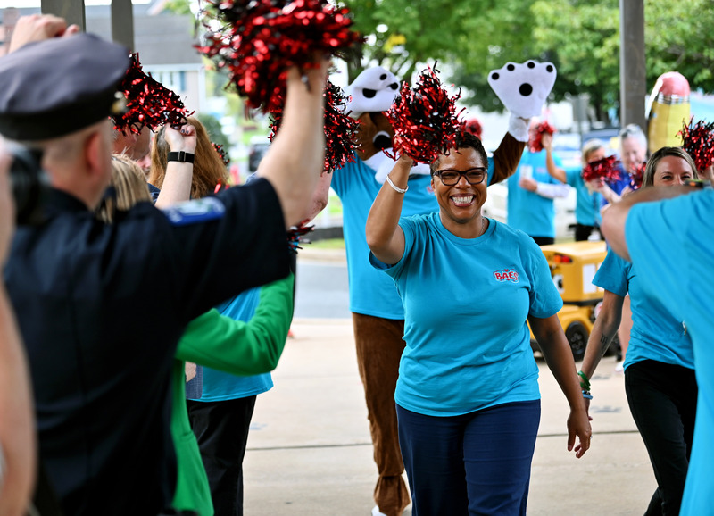 Dyann Mack smiling and walking through a group of cheering people