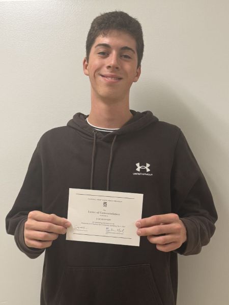 Student holding certificate from PSAT/NMSQT