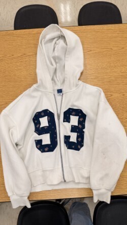 A collection of miscellaneous clothing items and cups in a variety of colors, styles, and sizes.