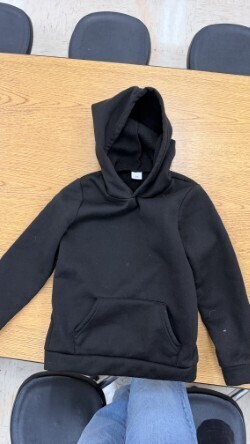A collection of miscellaneous clothing items and cups in a variety of colors, styles, and sizes.