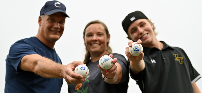 Dr. Bulson, Mrs. Hultquist and Trae McVicker posing and showing Aberdeen Ironbirds baseballs to the camera