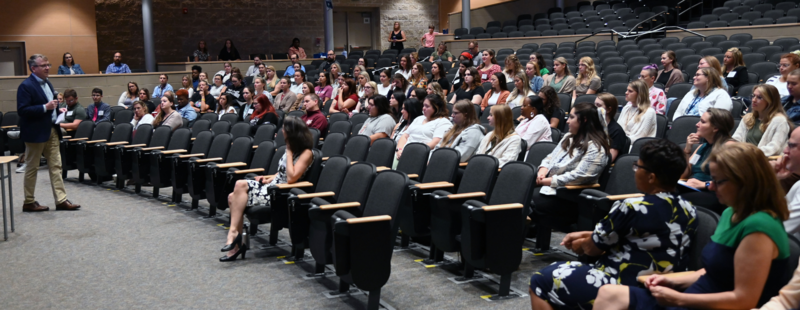 Mr. Wade Sewell speaks with a group of new teachers in the Havre de Grace Middle/High School Auditorium