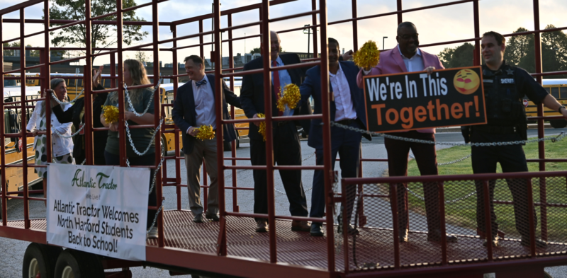 Staff on a trailer pulled by a tractor on the first day of school