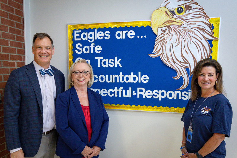 Dr. Bulson, Dr. Wright and Dr. Gerringer stand in front of a bulletin board at Abingdon Elementary School