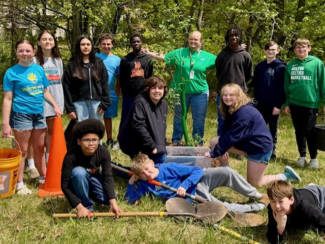 Group of middle school student pose with their planted sapling