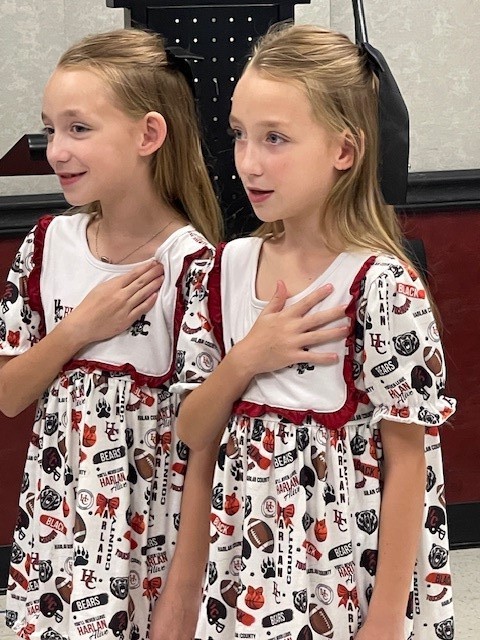 Raelynn and Springlynn Harrison leading the Board of Education in the Pledge of Allegiance. 