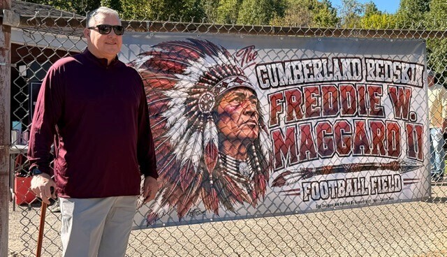 Freddie Maggard with a temporary banner for the naming of the field.