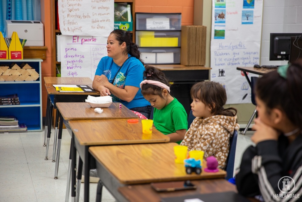 student and staff sitting at their desks