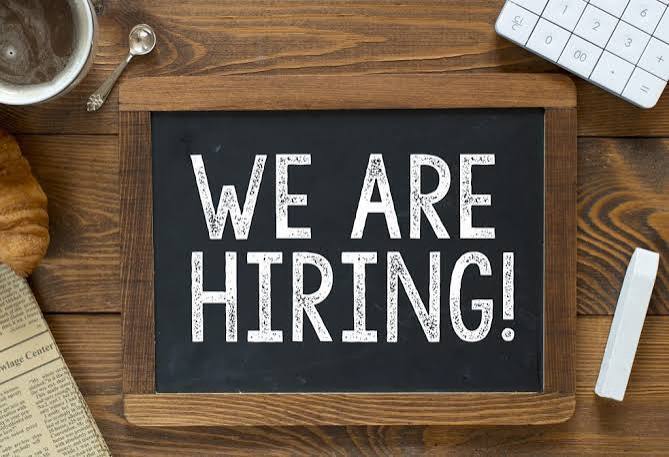 "we are hiring" on a  chalkboard and number pad