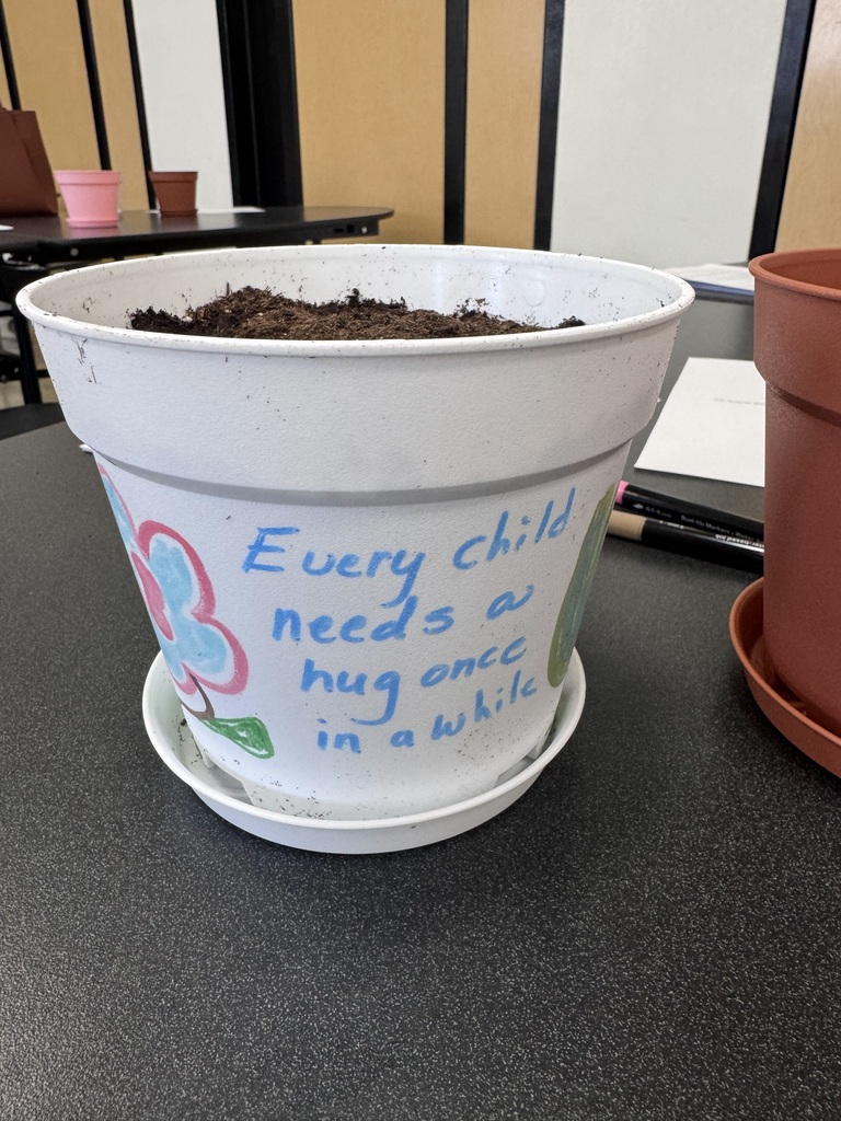 A pot with every child needs a hug once and a while painted on it
