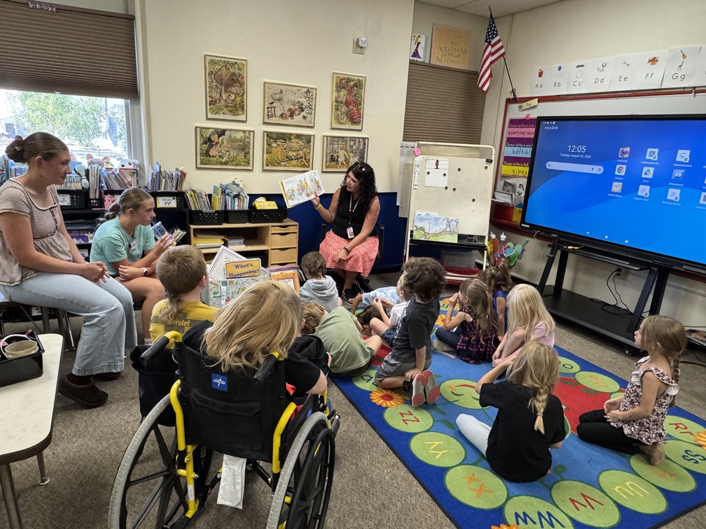 an adult reading a story to kids sitting on the floor