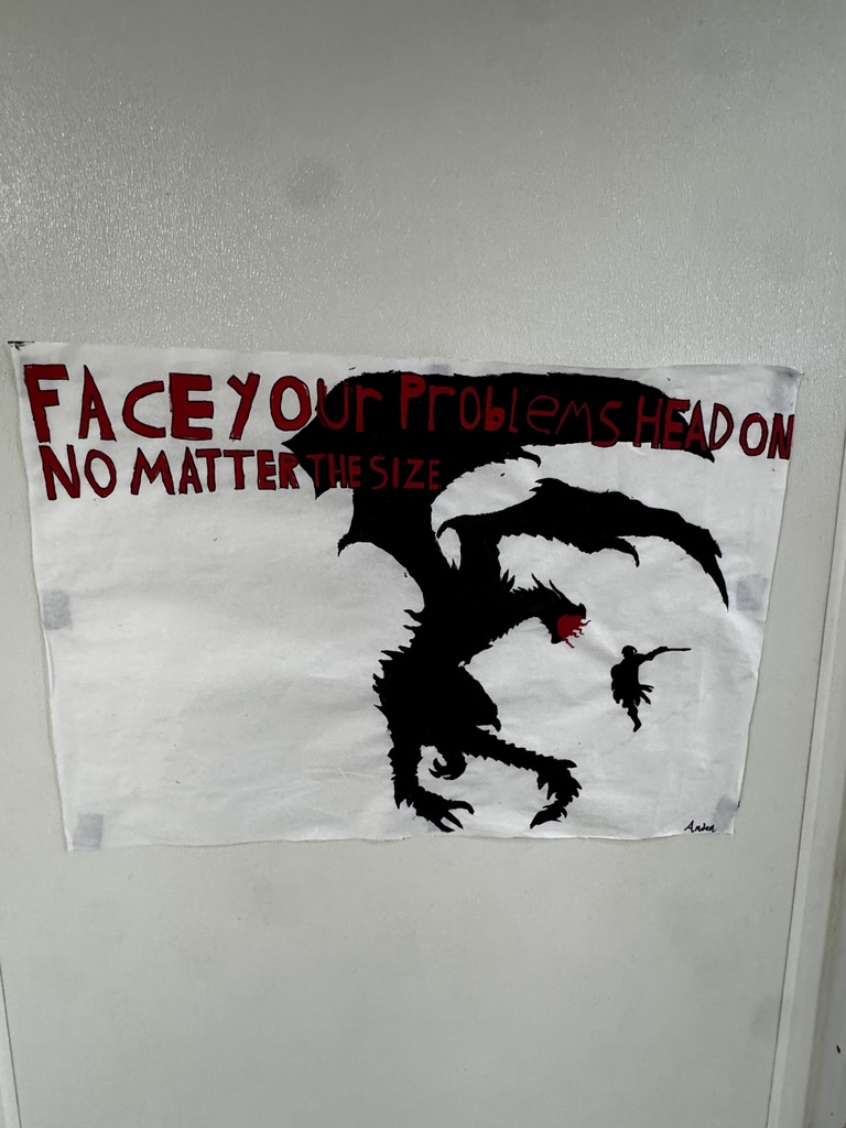 sign on elementary wall "face your problems head on" and artwork of a dragon
