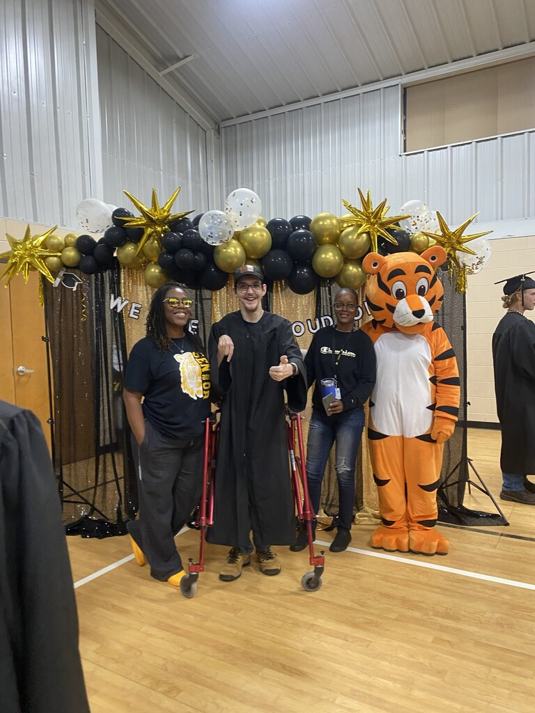 A former student and staff with the mascot