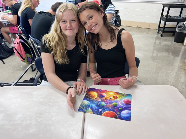 students posing with completed puzzle