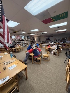 Teams working on the BreakoutEDU puzzles in the library