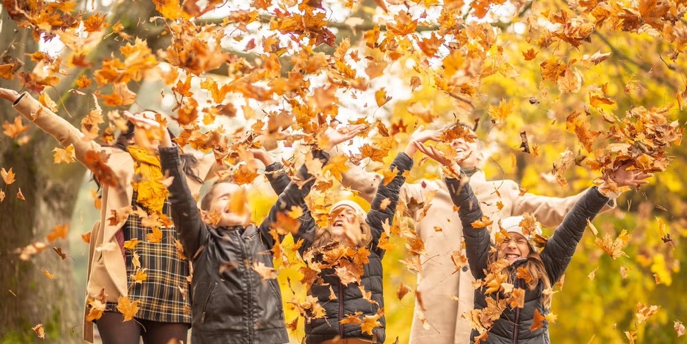 People tossing leaves in the air