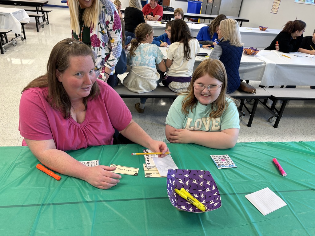 parent sitting with child at bingo for books at victory elementary