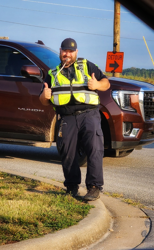 School resource officer welcoming kids and directing traffic