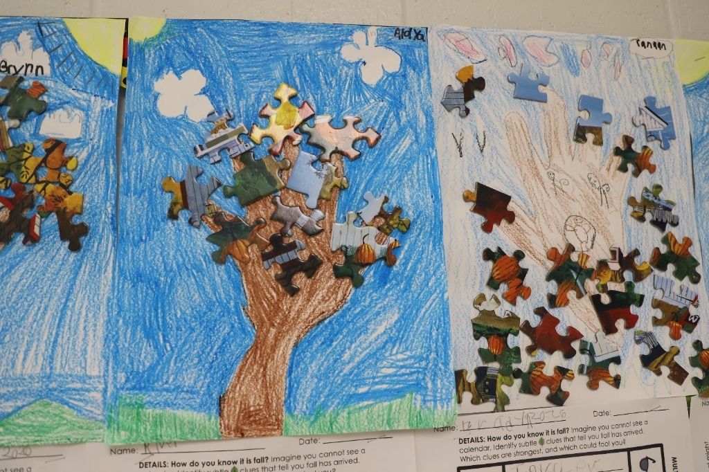 "Child-drawn artwork of handprint trees with puzzle pieces glued on as colorful fall leaves, displaying student responses to 'How do you know it is fall?'"