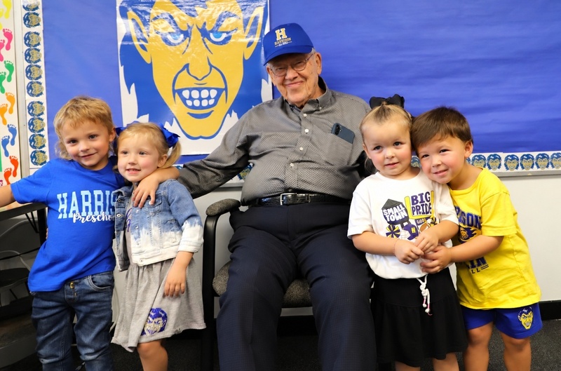 Dr. Joe Bennett, Harrison's oldest living Goblin alumnus, leans forward in his chair while admiring a blue Harrison Alumni cap presented to him during a special preschool visit.