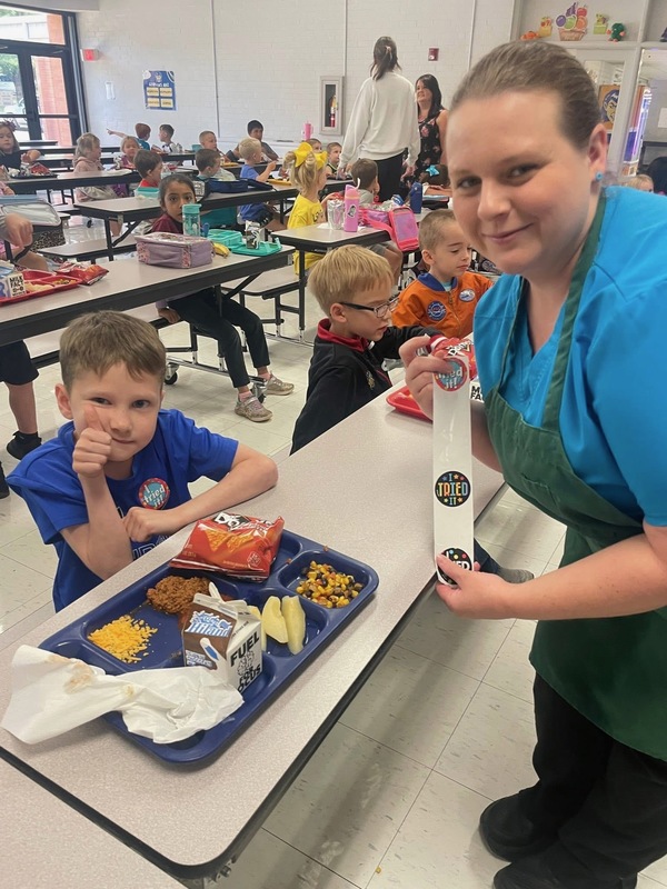 student giving thumbs up and getting a free "I tried it" sticker!