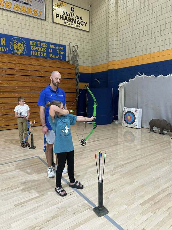 student practicing archer with Coach Doshier