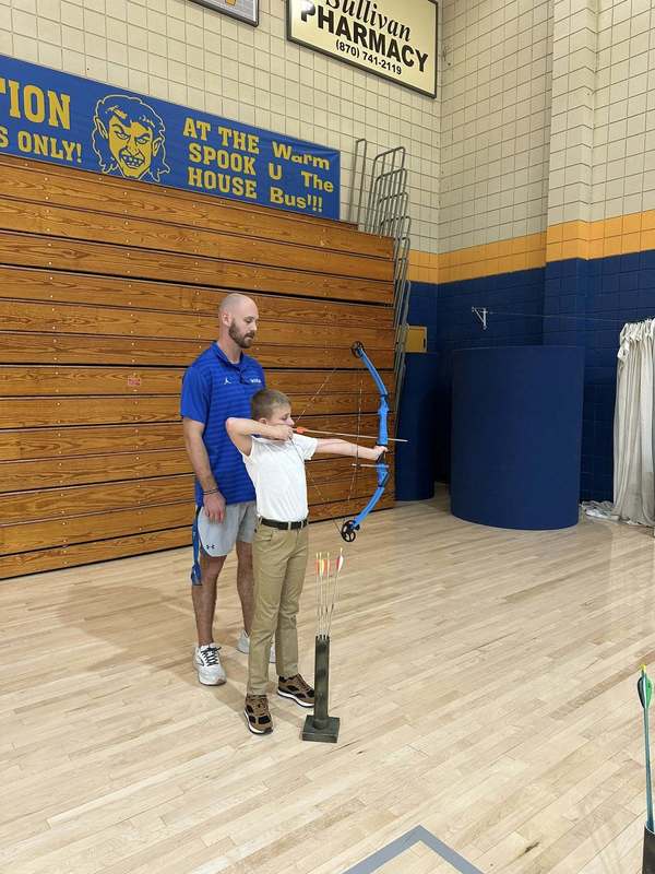 student practicing archer with Coach Doshier