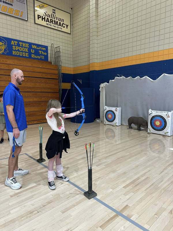 student practicing archer with Coach Doshier