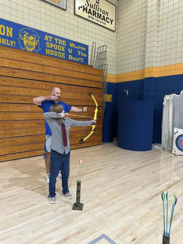 student practicing archer with Coach Doshier
