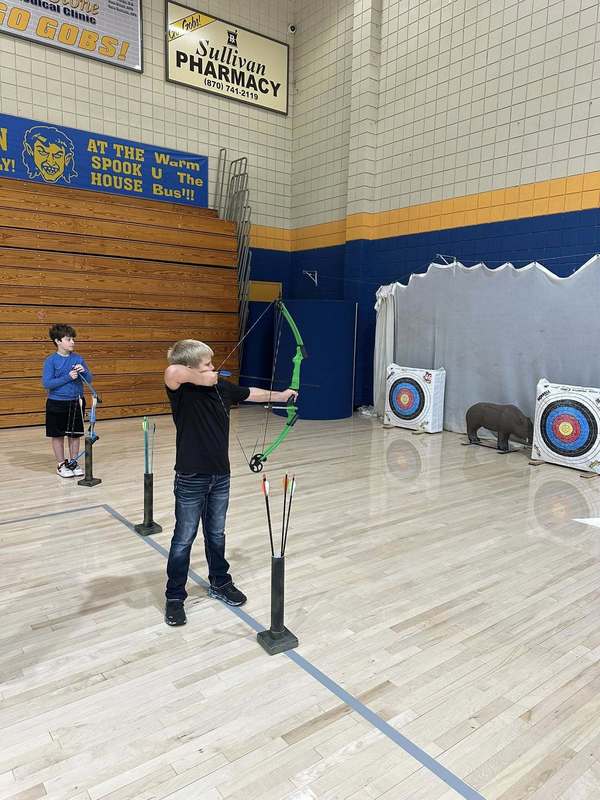 student practicing archer with Coach Doshier