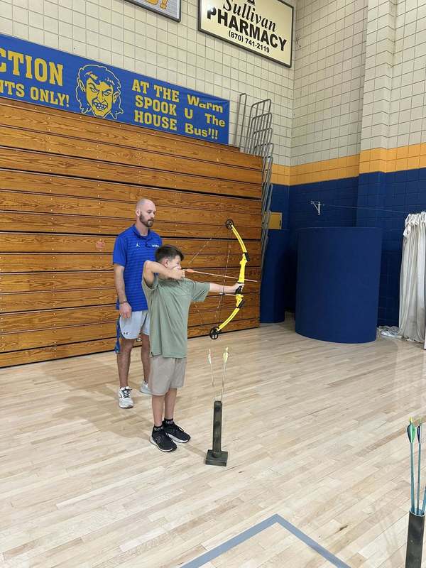 student practicing archer with Coach Doshier
