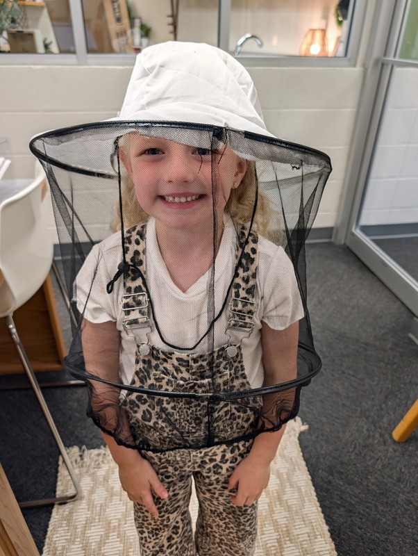 student in beekeeper outfit