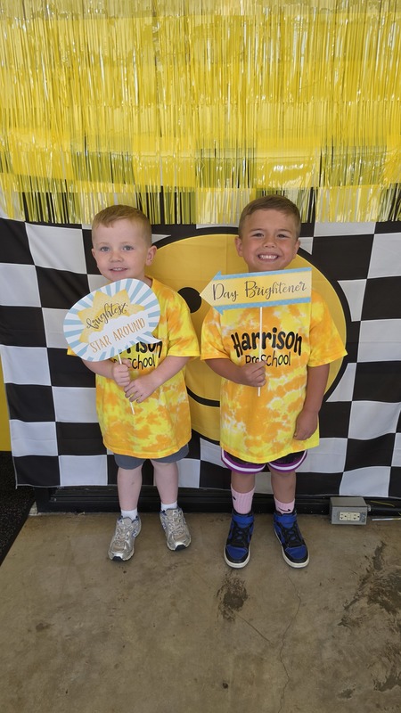 Two preschool students holding photo booth signs