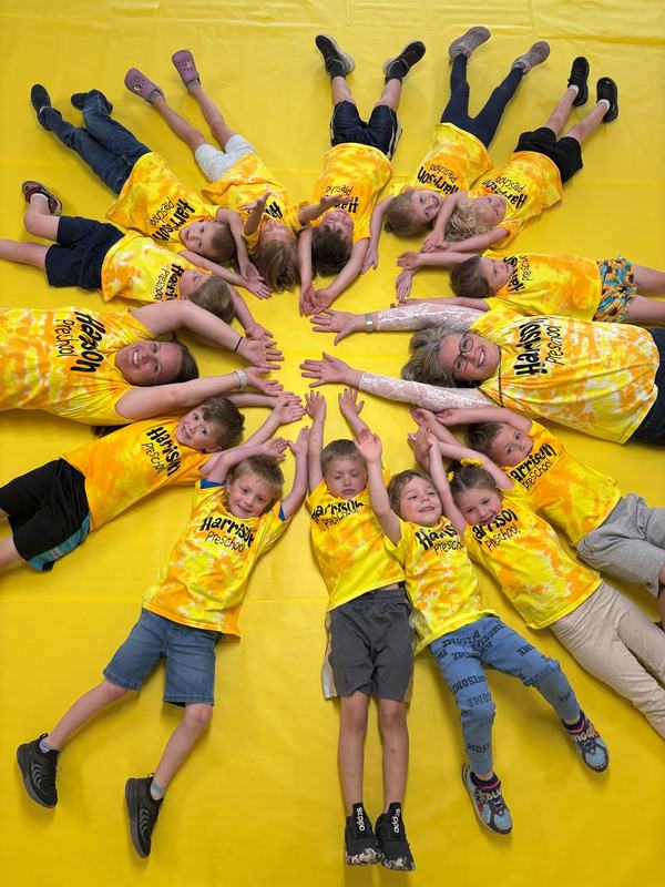 Preschool students in a circle wearing Yellow Day shirts