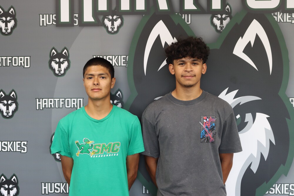juan romero and josais robles post in front of the hartford husky backdrop