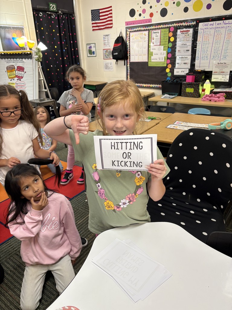a student holding a sign that reads no kicking or hitting