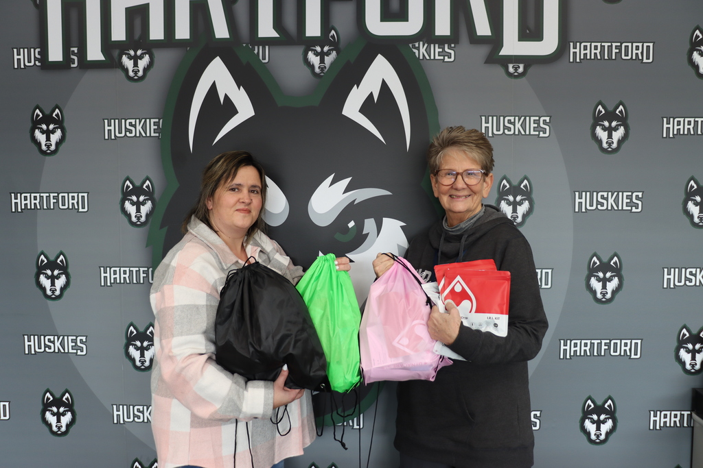 photo of HPS school nurses Amber Beltran and Cathy Lancaster with APP products in front of the hartford husky backdrop