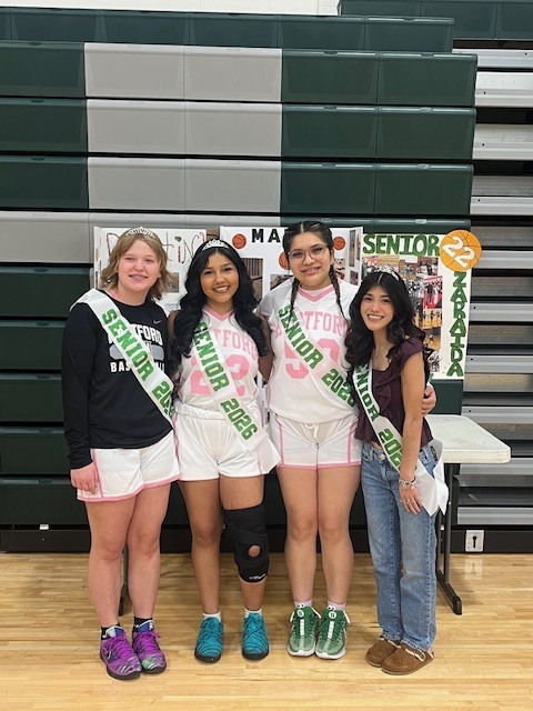 varsity girls basketball and cheer seniors pose in front of their decorations