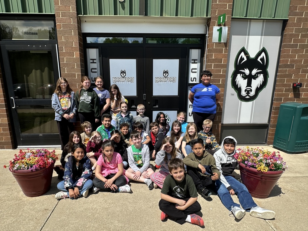 Nehs students pose with the flowers they planted in front of the elementary