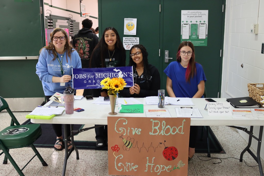 jmg teacher and students pose in front blood drive sign