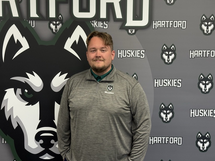 HPS tech director Forrest Ward in front of Hartford husky logo wall