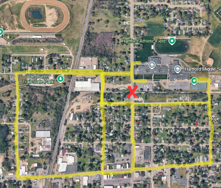An aerial map of Hartford showing the area around Hartford Middle School, Hartford Athletic Field, Van Buren Trail State Park, and nearby neighborhoods. Yellow highlighted lines mark designated alternate traffic routes around a railroad crossing construction site. A red “X” marks the railroad crossing closure near the center of the map. The detour routes loop around residential streets and connect to surrounding roads west, south, and east of the closure area.